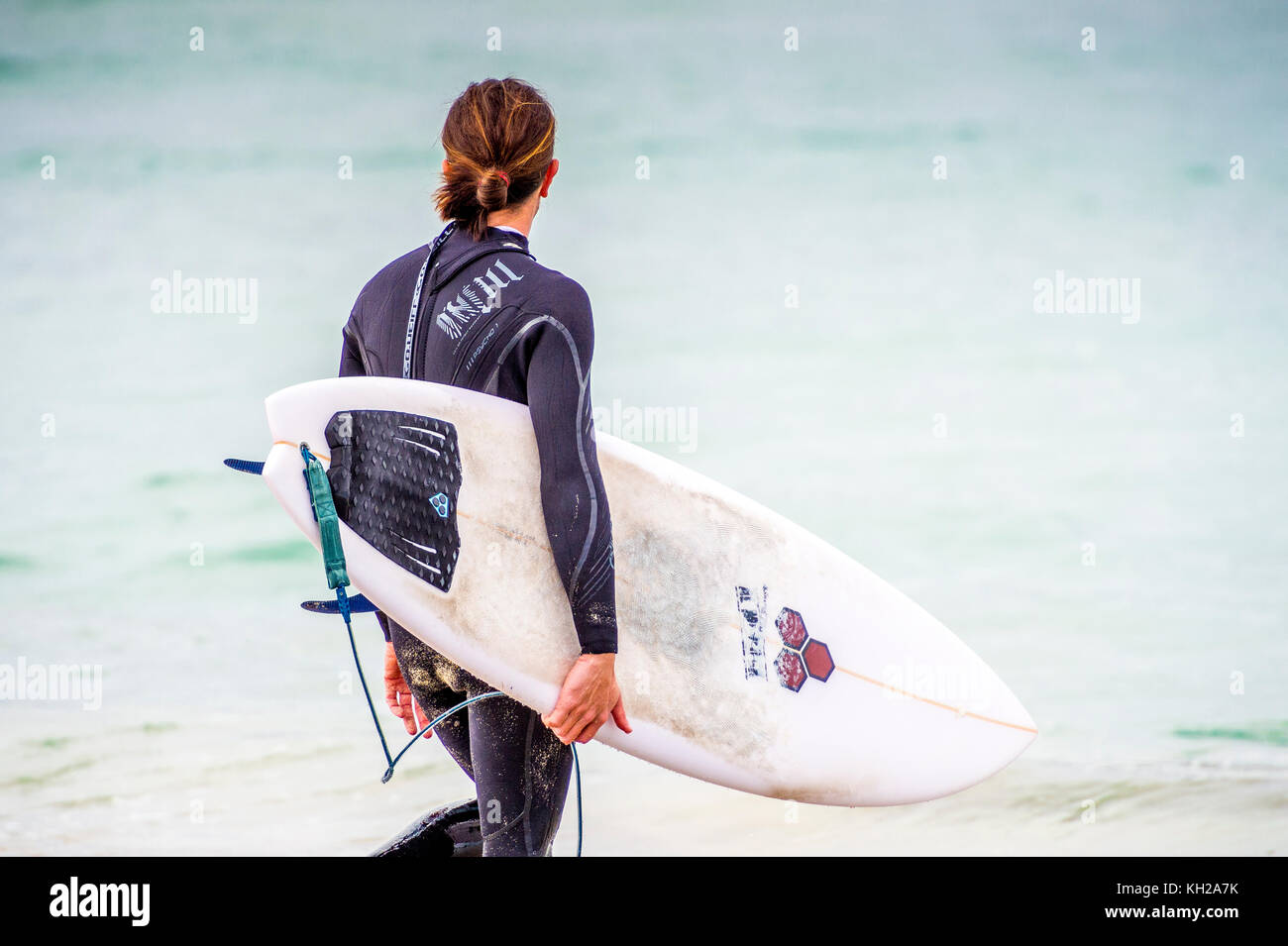 A surfer enters the water at the iconic Bondi Beach, Sydney, NSW, Australia Stock Photo