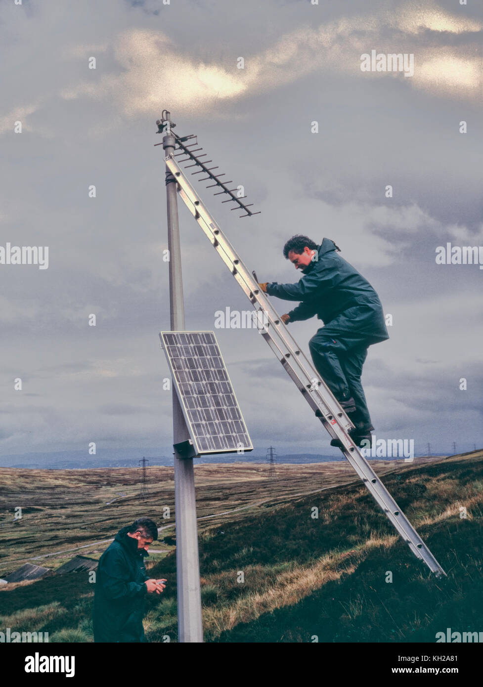 A two-man team servicing one of a network of buried seismometers in the Pentland Hills, Scotland Stock Photo