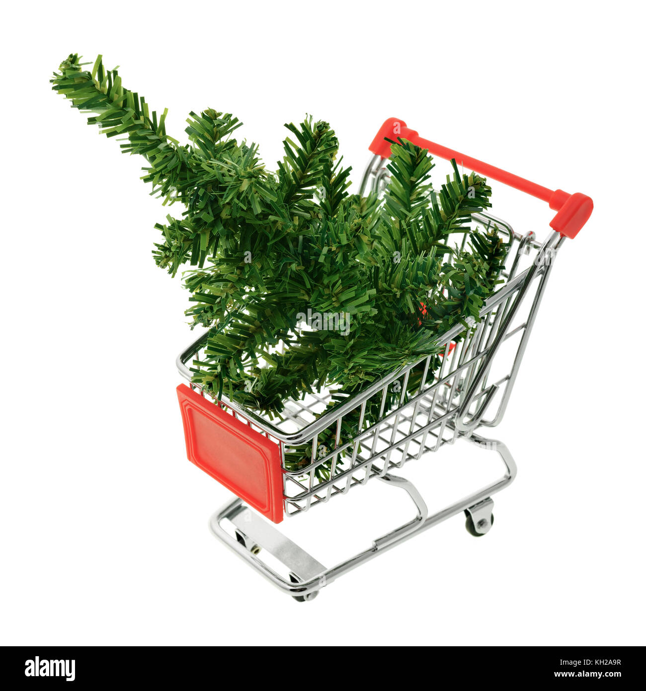 Isolated objects: toy Christmas tree in a shopping cart, on white background, seasonal shopping concept Stock Photo