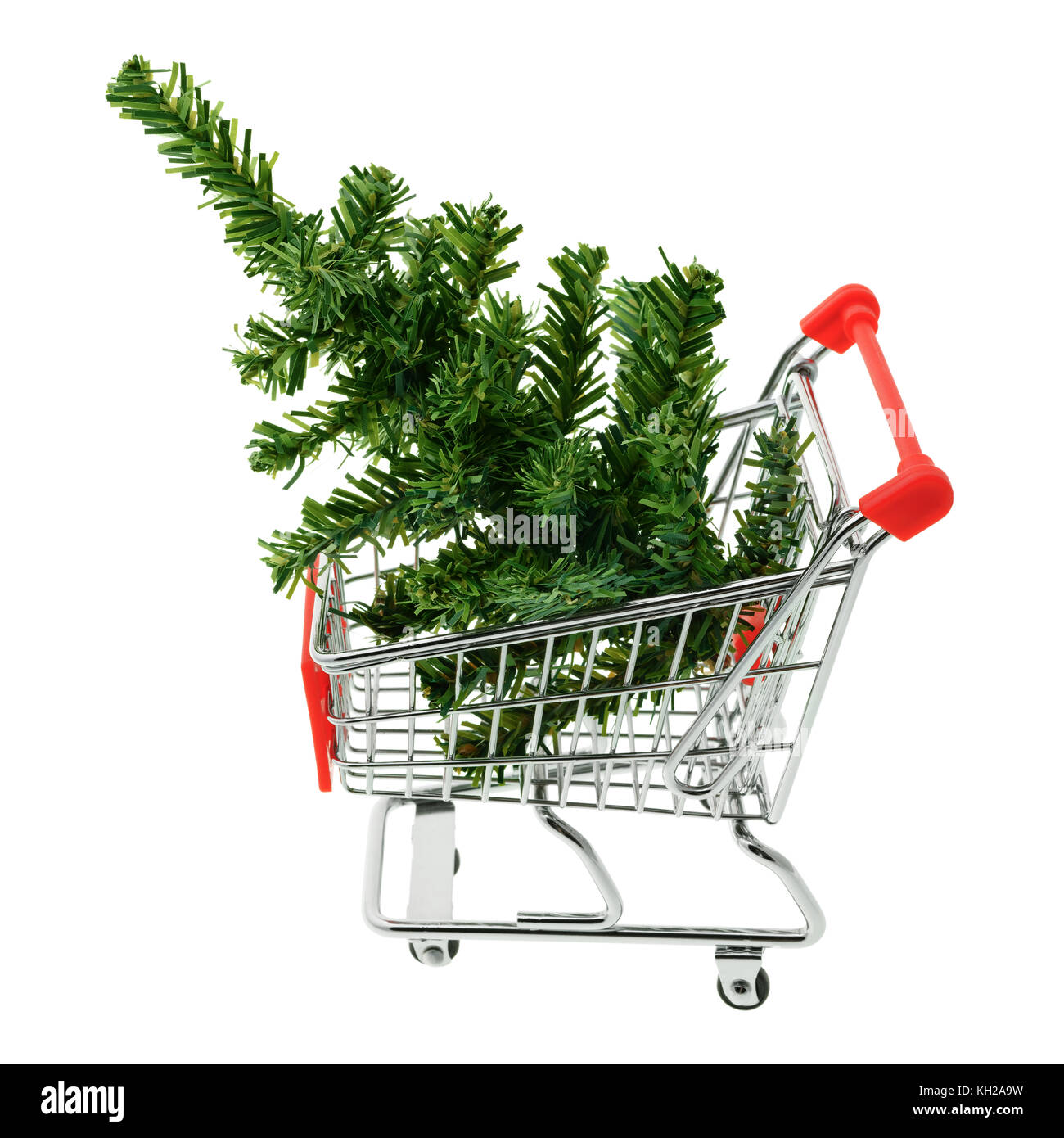 Isolated objects: toy Christmas tree in a shopping cart, on white background, seasonal shopping concept Stock Photo