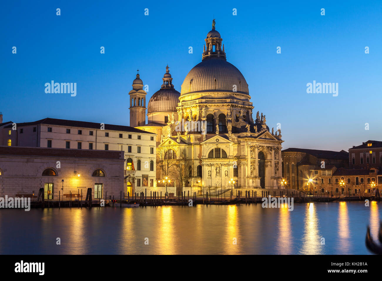 Basilica di Santa Maria della Salute, Grand Canal, Dorsoduro, Venice, Veneto Italy illuminated at night at blue hour  with reflections on the water Stock Photo