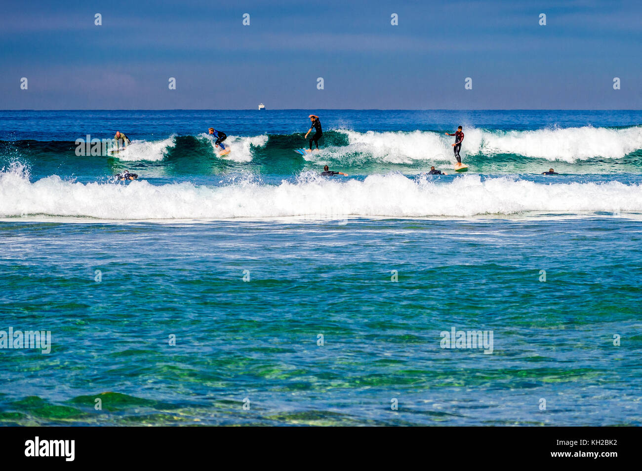 Multiple surfers ride a wave at Sydney's iconic Bondi Beach, NSW ...