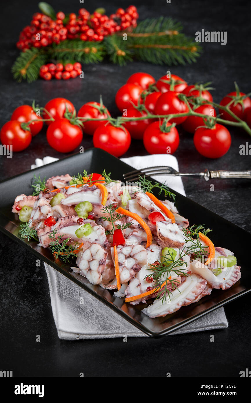 Plate with octopus salad on table decorated for winter holidays. Stock Photo