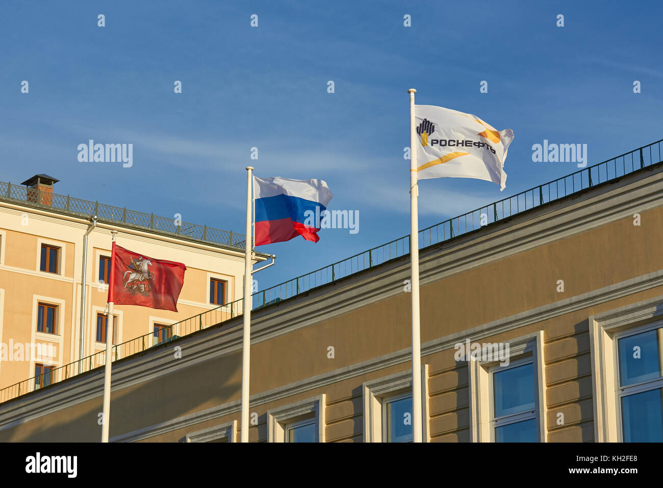 Moscow, Russia - September 1, 2016: A Russian Federation flag flies between flags of displaying the Moscow city coat of arms (at left), and the Rosnef Stock Photo