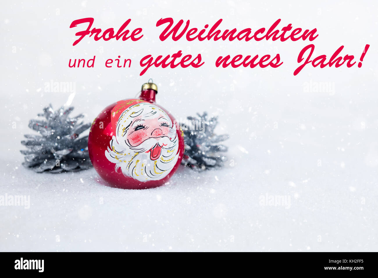 Group of colorful Christmas ball with drawing of Santa Claus and pines with text in German 'Frohe Weihnachten und ein gutes neues Jahr' in white snow  Stock Photo