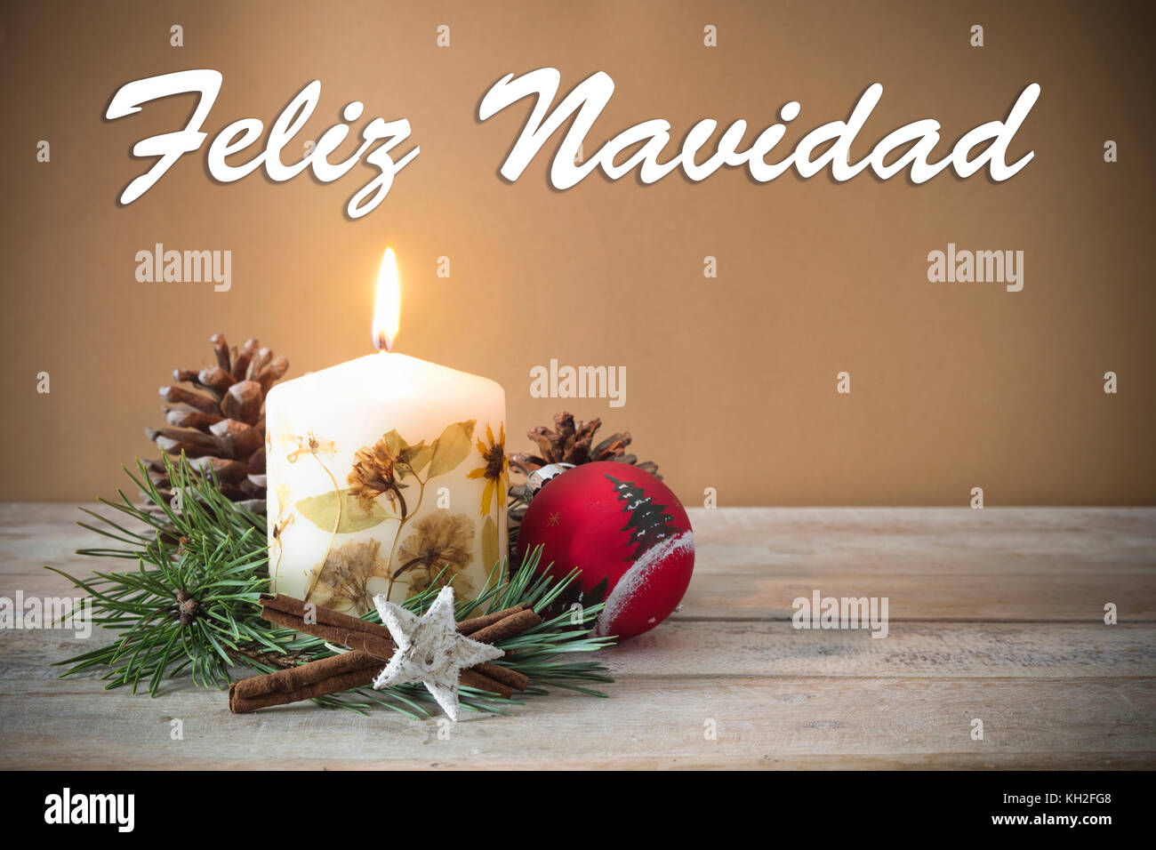 Christmas decoration with candle, pine, bauble, with text in Spanish "Feliz Navidad" in wooden