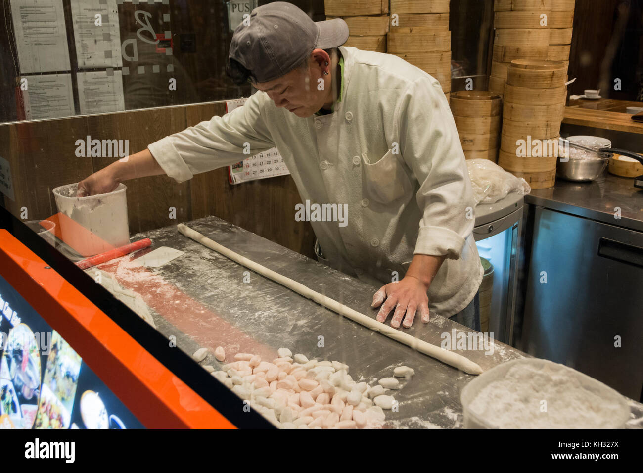 A young Chinese chef rolls Chinese Dim Sum in China Town, London, England, UK. Stock Photo