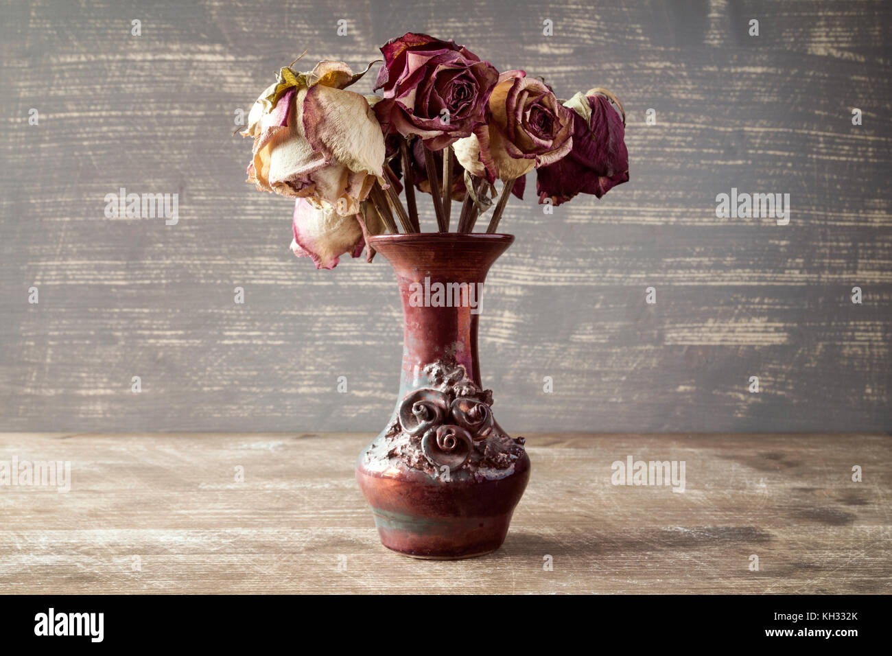 Bouquet of dry roses in a vase on wooden background Stock Photo - Alamy