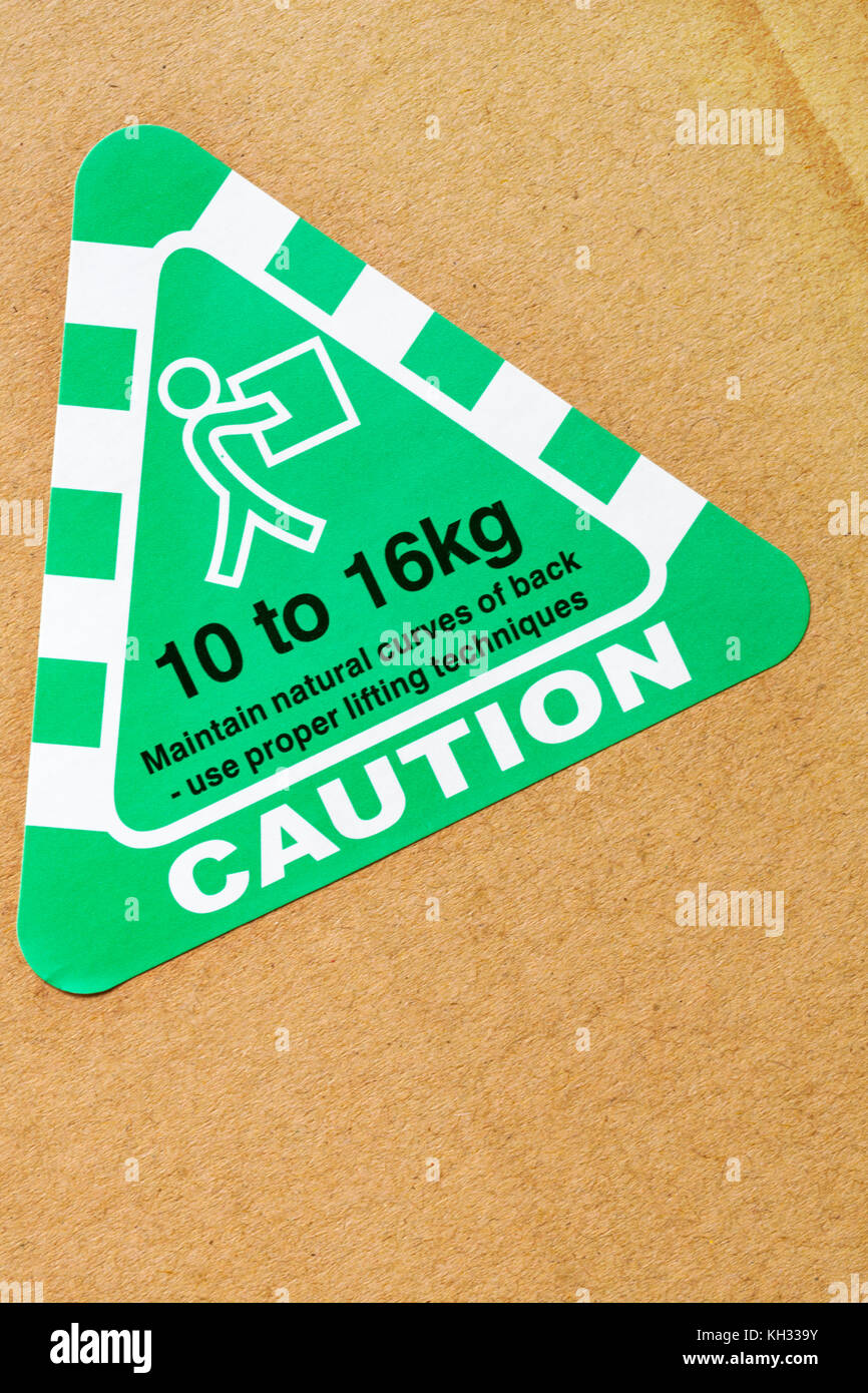 caution maintain natural curves of back - use proper lifting techniques 10 to 16kg sticker stuck on cardboard box Stock Photo