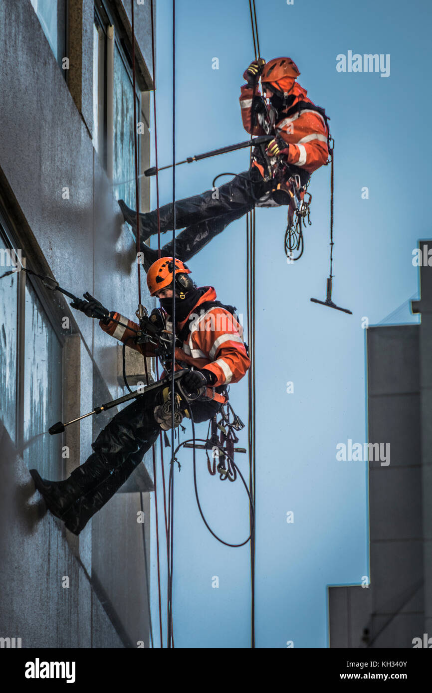 Window cleaners with high pressure hoses on a highrise development in