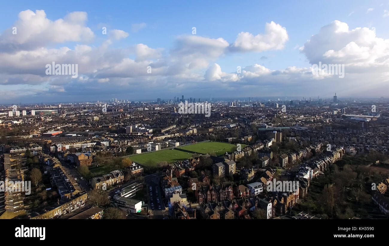 Aerial Urban Downtown View of London City with Green Pitch and Blue Sky Clouds. Landmarks in the Background at Distance Stock Photo