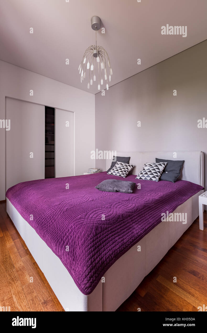 Luxurious bedroom with double bed, wardrobe and chandelier Stock Photo