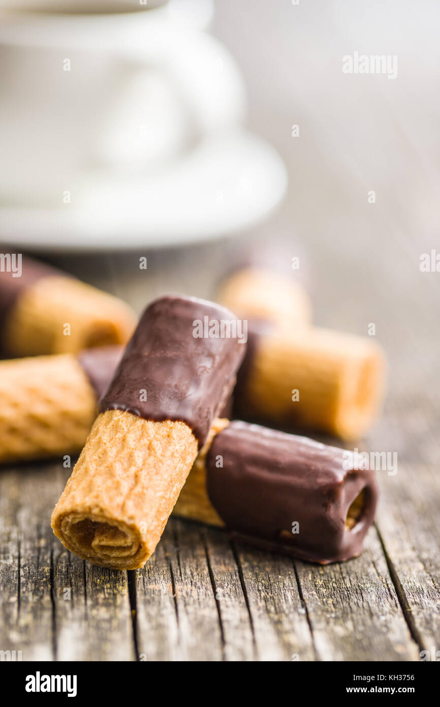Sweet dessert. Biscuits rolls with chocolate icing on old wooden table