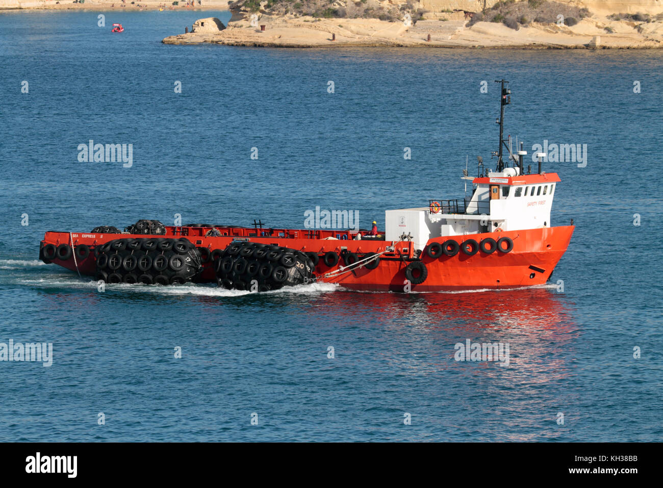 The offshore supply ship Sea Express III towing a set of pneumatic rubber marine fenders as it enters harbor in Malta. Maritime support logistics. Stock Photo
