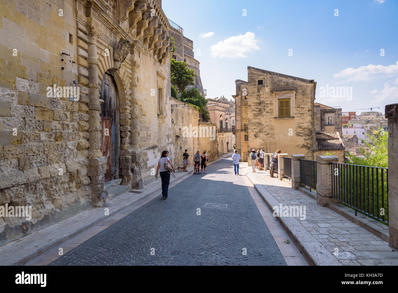 Matera, Italy - September 2, 2016: Tourists visit Via Duomo street leading to Piazza del Duomi in Matera. Stock Photo