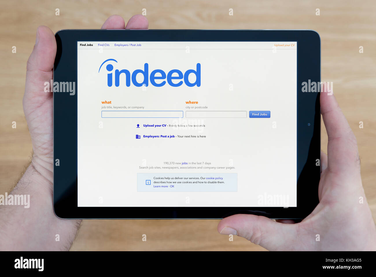 A man looks at the Indeed recruitment agency website on his iPad 