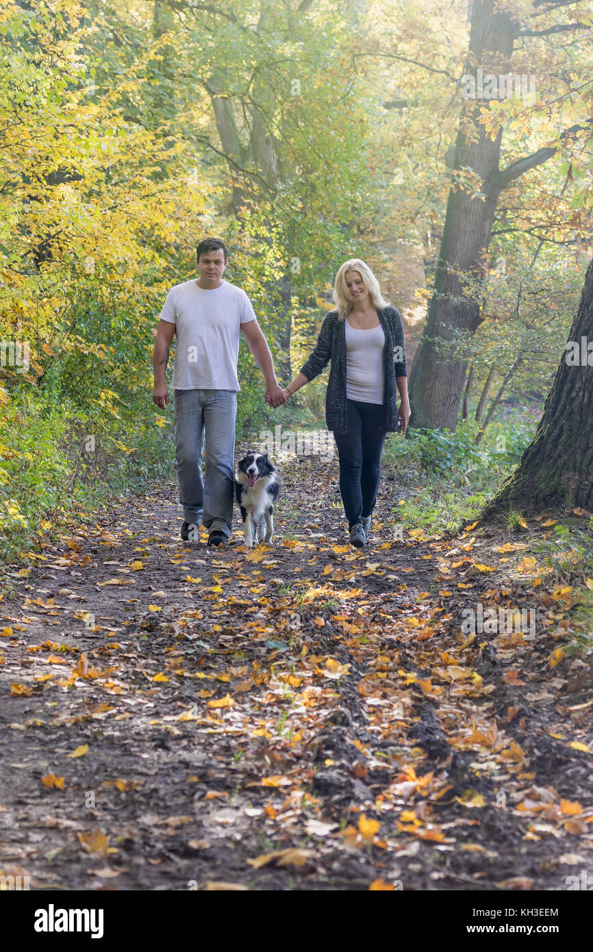 Front view of a couple of two young people walking through an autumn ...