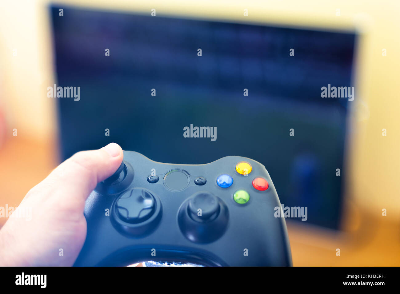 Hand holding game console controller playing sport game on the television Stock Photo