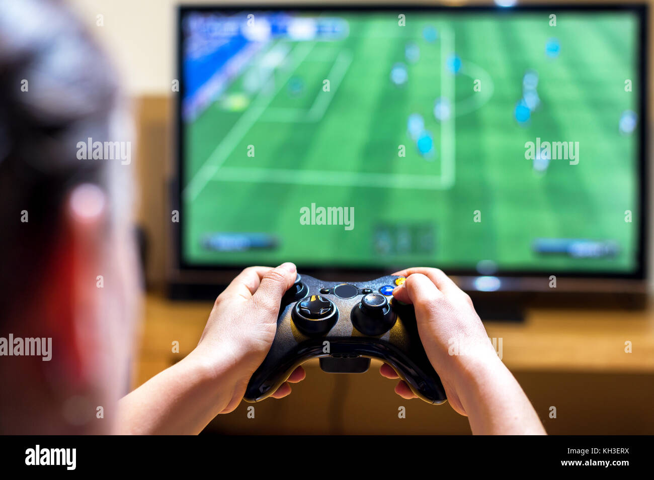 Close up of female hands holding a joystick controller while playing a video games at home, narrow depth of field on hands Stock Photo