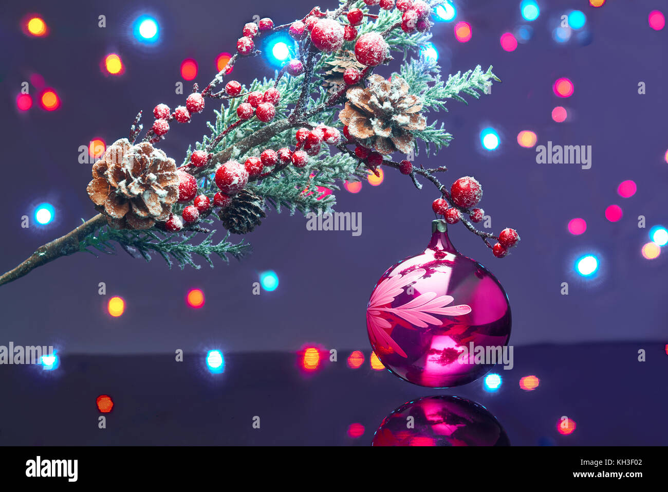 Christmas Card with christmas decorative bauble and frosty fir branch over bokeh light background Stock Photo