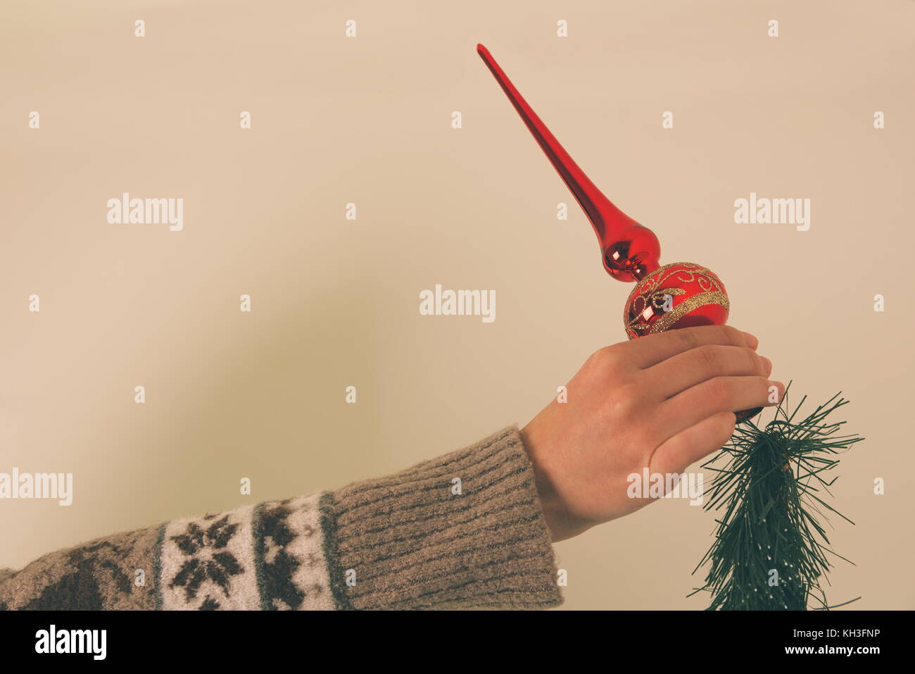 Putting Red Christmas Treetop Ornament on Top of Christmas Tree Stock Photo