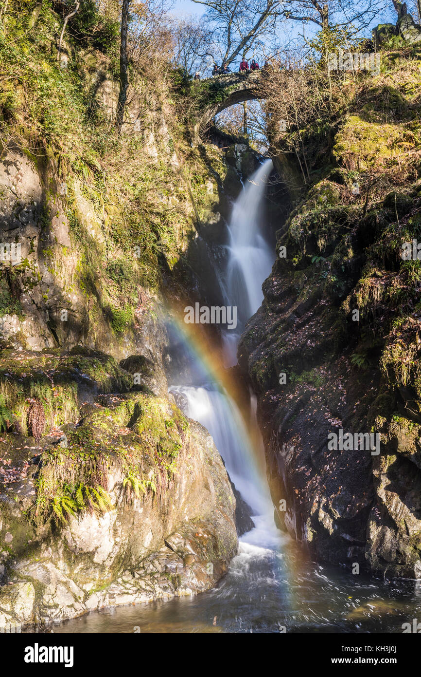 The Aira Force waterfall, managed by the National Trust with a rainbow lighting up the flow Stock Photo