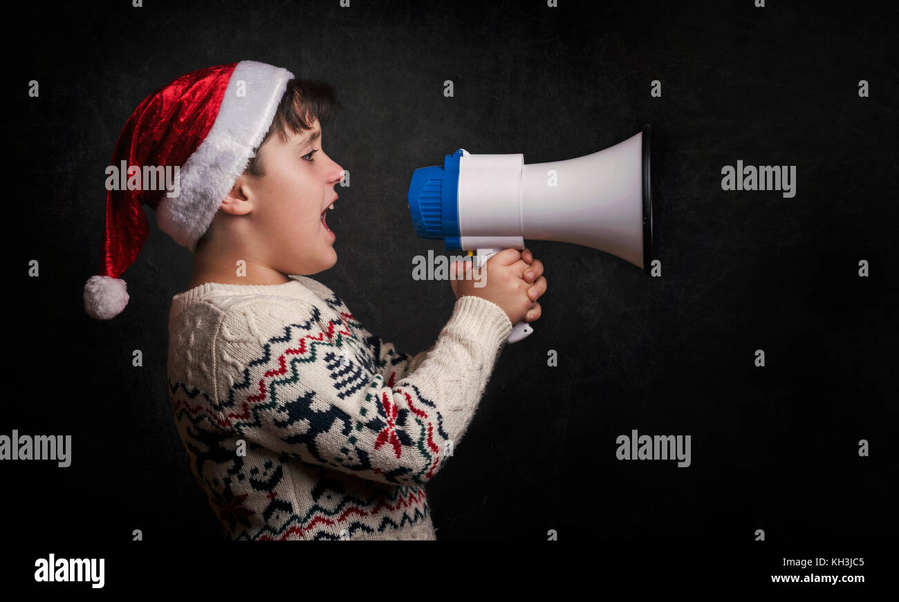 boy with a megaphone at christmas on black background Stock Photo