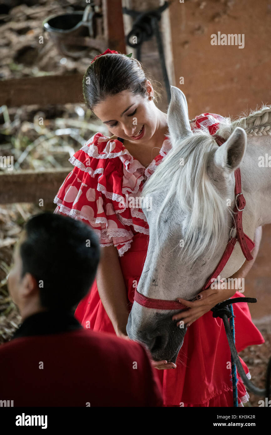 Central America, Costa Rica, Alajuela Province, Rancho San Miguel. Traditional Andalusian horse ranch, Woman in typical Spanish attire with gray Andal Stock Photo