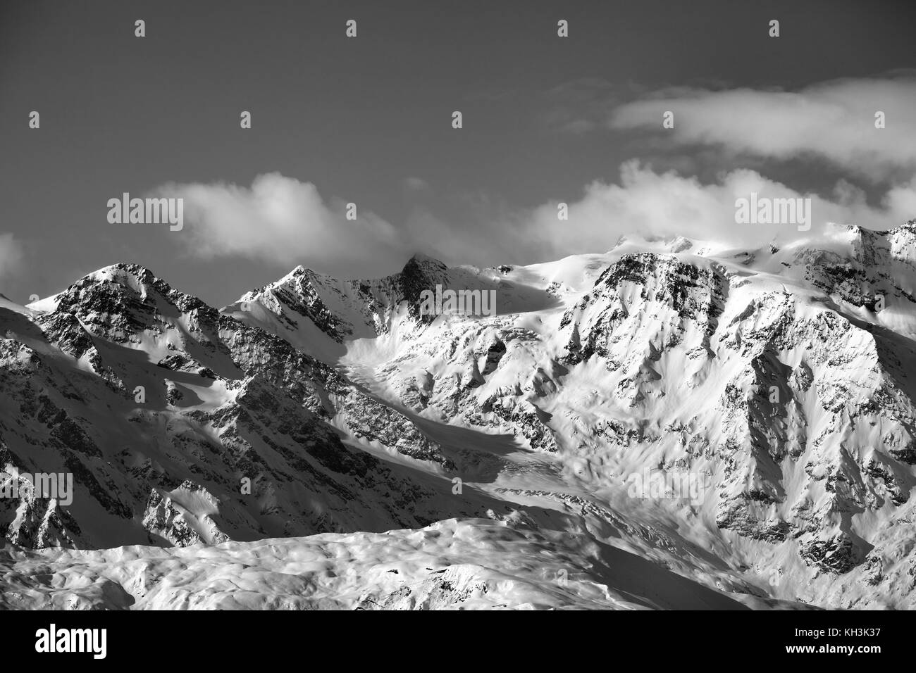 Black and white snow mountains and glacier at sunny evening. Caucasus Mountains in winter. Svaneti region of Georgia. Stock Photo