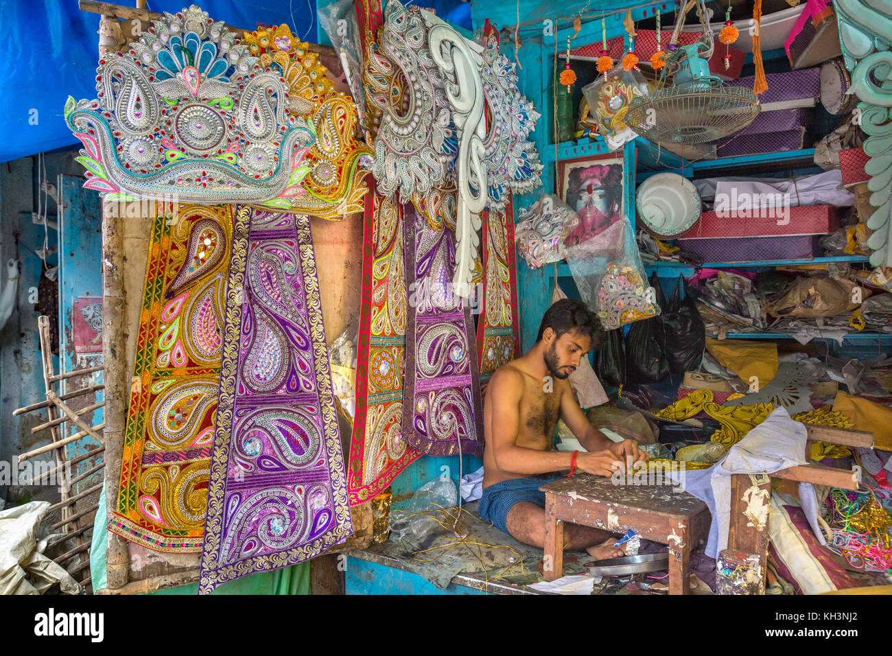 Artisan works on decorative items used on Indian idols and deities in his workshop at Kumartuli area of Kolkata, India. Stock Photo