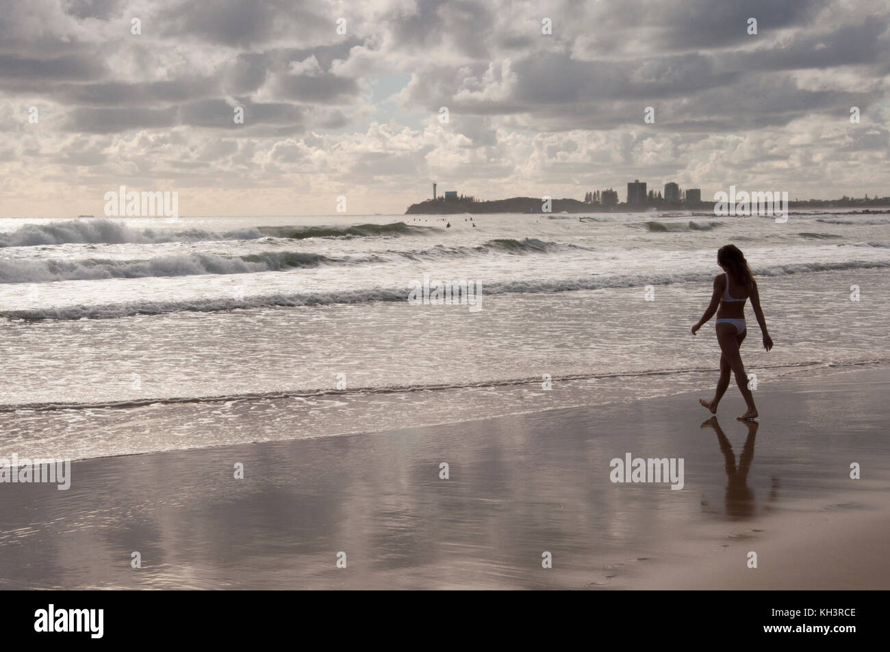 Early morning, a lone woman walking towards the surf at Alexandra Headland on the Sunshine Coast, Queensland, Australia Stock Photo