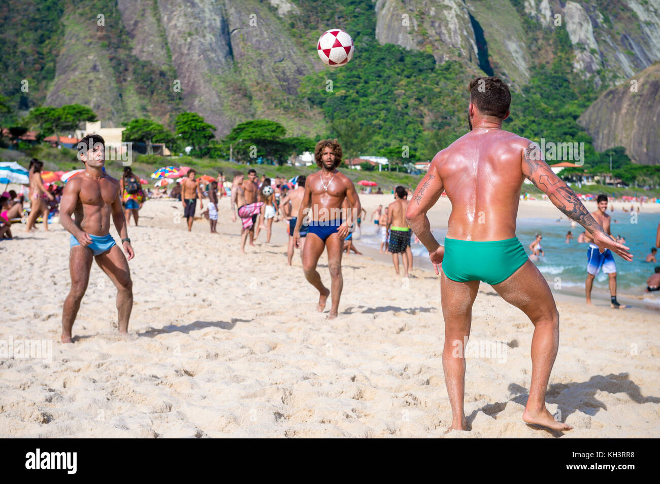 RIO DE JANEIRO - MARCH 4, 2017: Young Brazilians play a game of keepy-uppies (known locally as altinho) on the shore of Itacoatiara Beach. Stock Photo