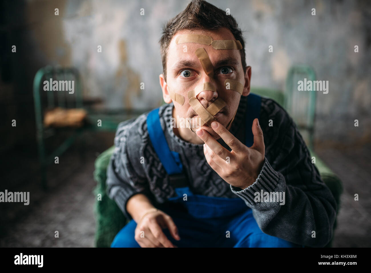 Madman, mouth sealed with plaster, violent patient Stock Photo