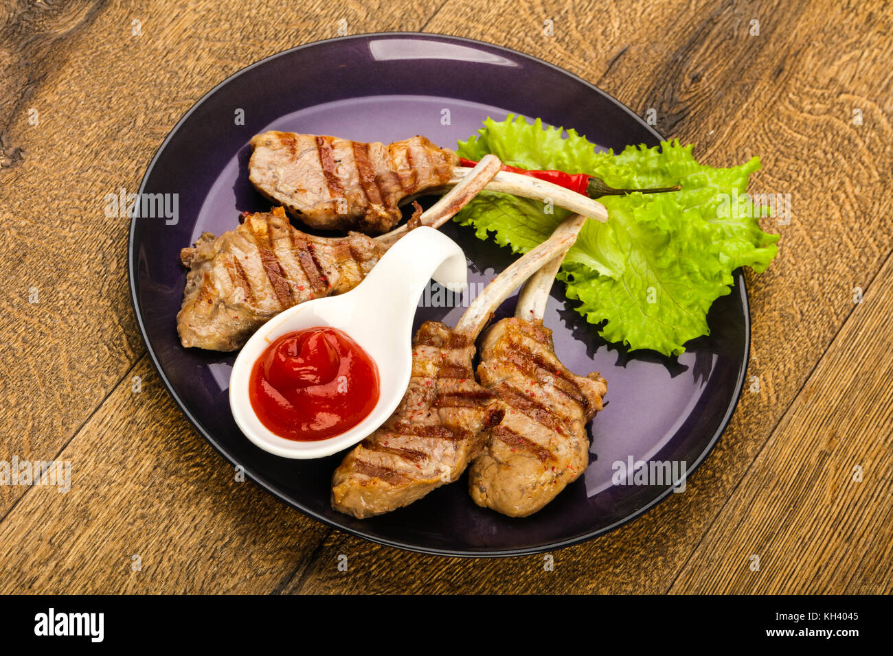 Grilled lamb with tomato sauce served salad leaves Stock Photo Alamy