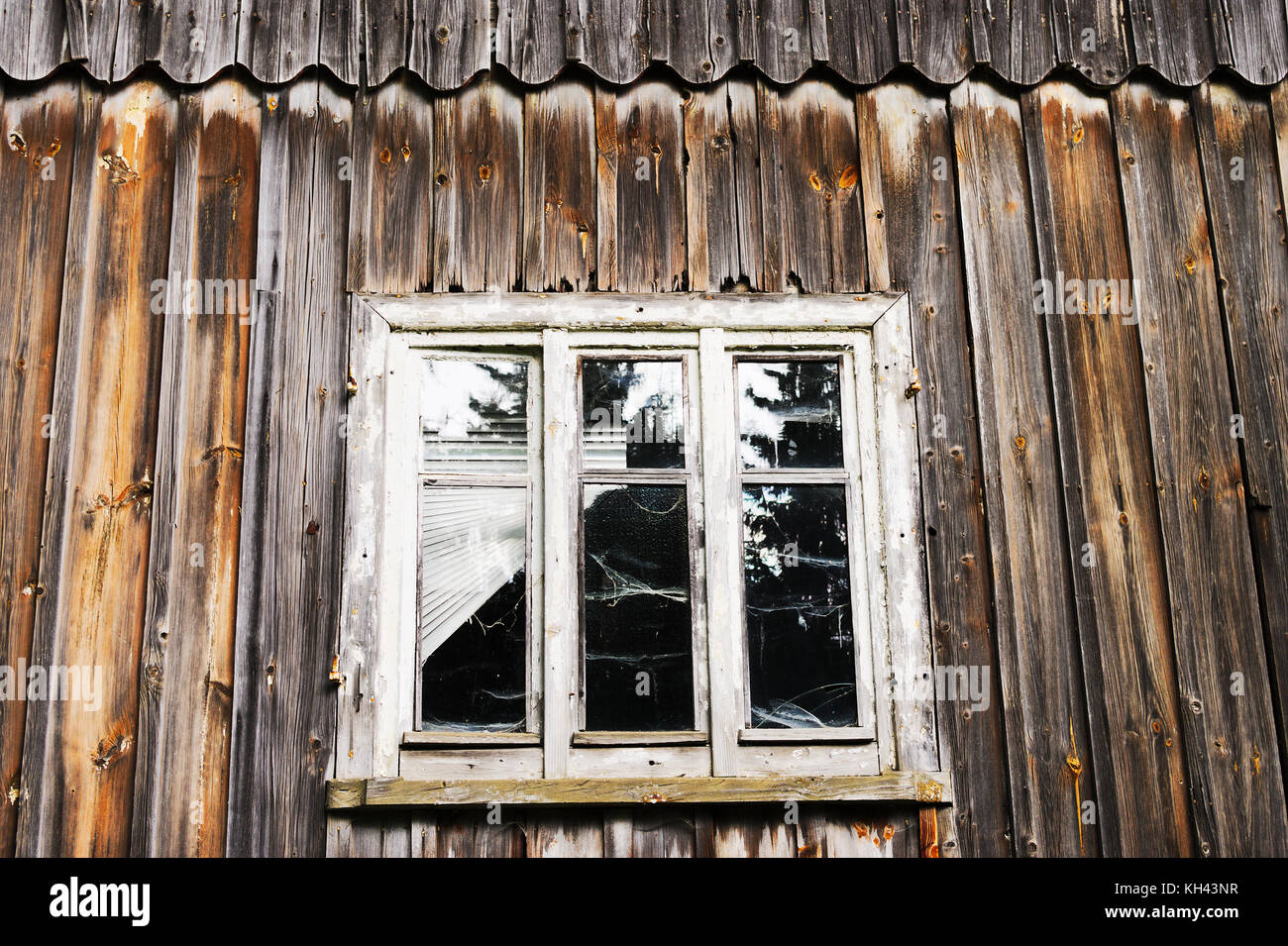 Window and wall of the old abandoned wooden house. Details of vintage wall and window frames. Sudetes, Poland. Stock Photo