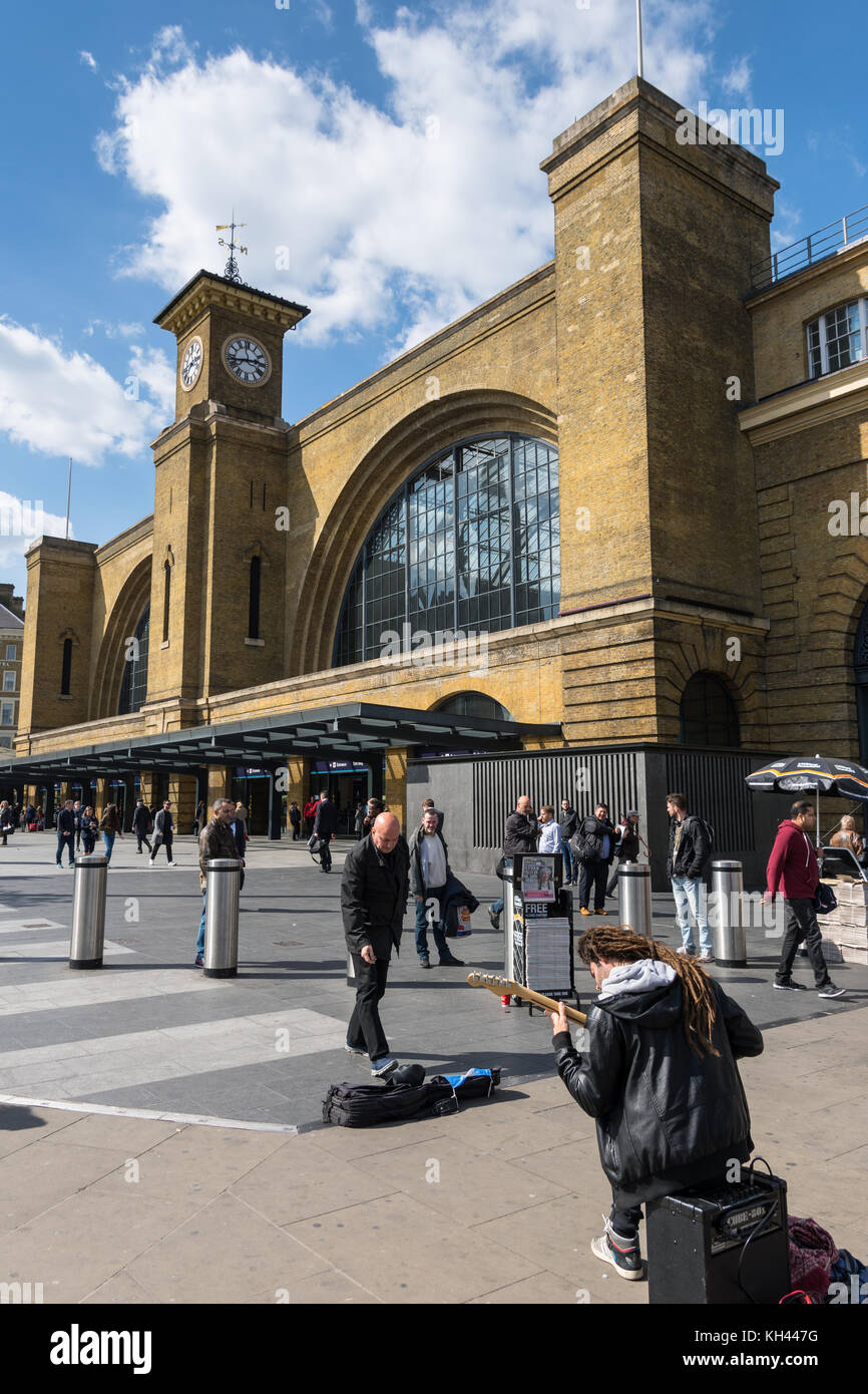 King's Cross Station London, front entrance and square with busker (street musician) Stock Photo