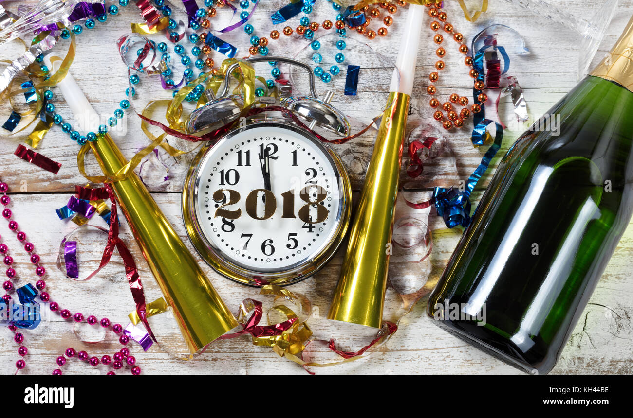 Clock showing Midnight for New Year 2018 surrounded by party objects and Champagne Stock Photo