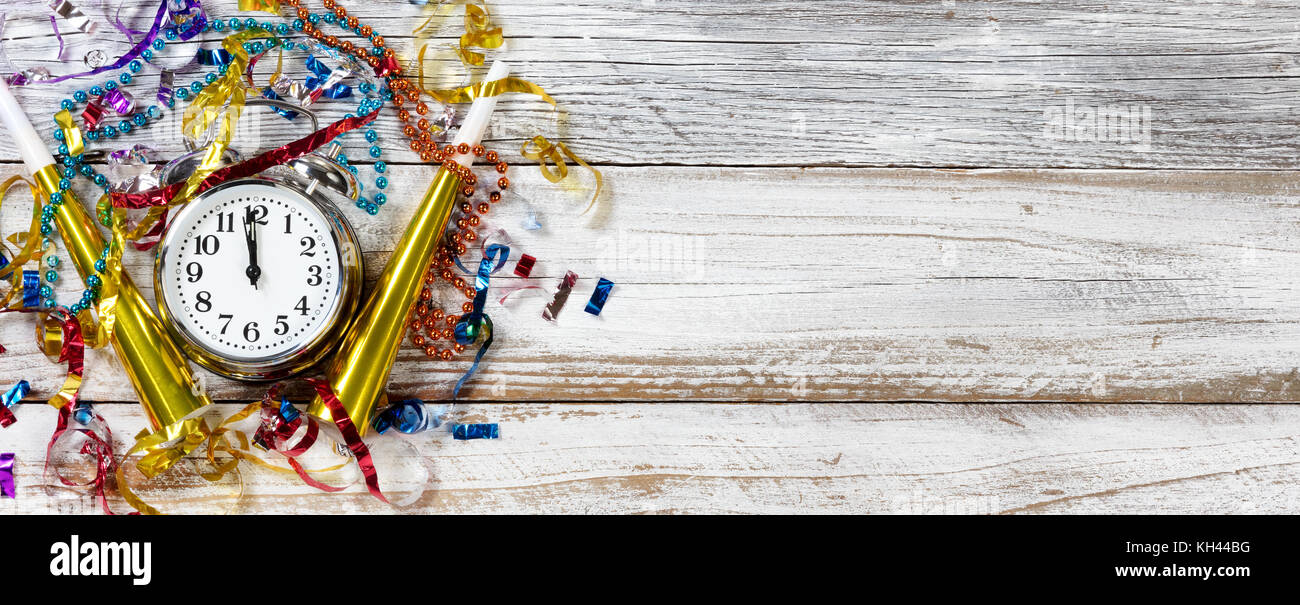 Clock strikes Midnight for New Year Celebration on rustic white table