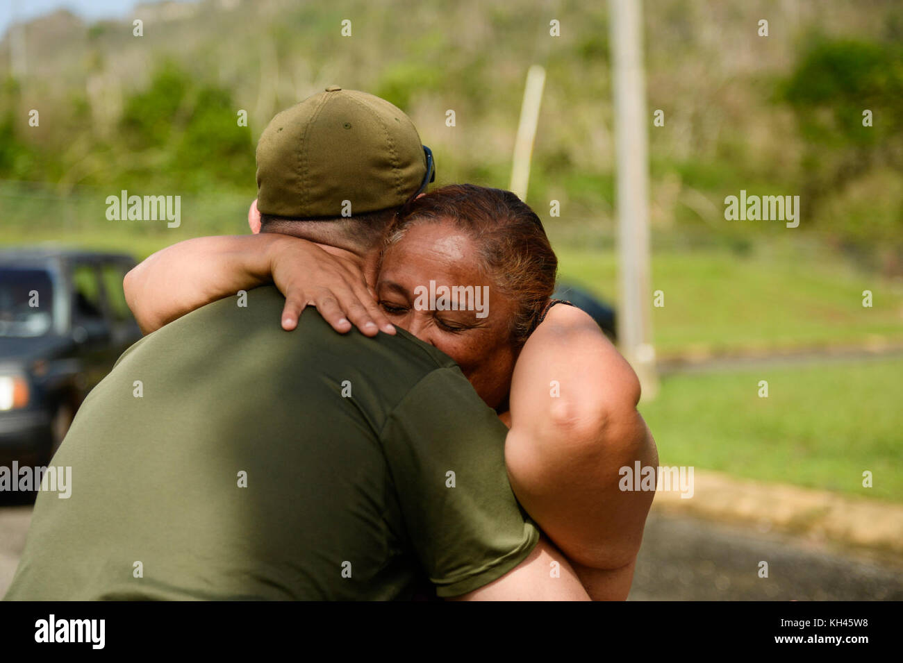 Marilyn Luciano hugs Brian Grayson, a U.S. Department of Homeland Security employee, after he let her use a satellite phone to contact her son for the first time since Hurricane Maria. The USDHS delivered food and water to isolated Puerto Rico residents as their bridge was destroyed by Hurricane Maria in the mountains around Utuado, Puerto Rico, Oct. 12, 2017. The Federal Emergency Management Agency and its federal partners continue 24-hour operations to conduct missions in support of those affected by Hurricane Maria. (U.S. Air Force photo by Master Sgt. Joshua L. DeMotts) Stock Photo