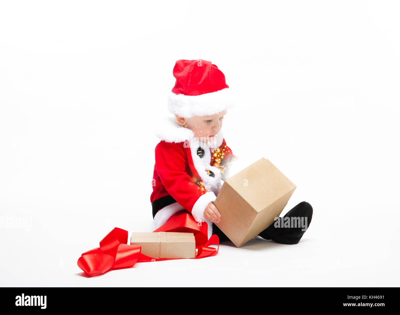 Santa Claus baby in red christmas clothes with gift box isolated on white Stock Photo