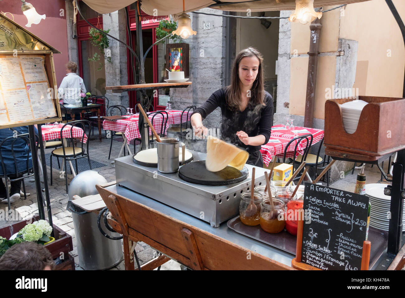 Young Woman is Preparing Crepes outdoors, Old Lyon, France Stock Photo
