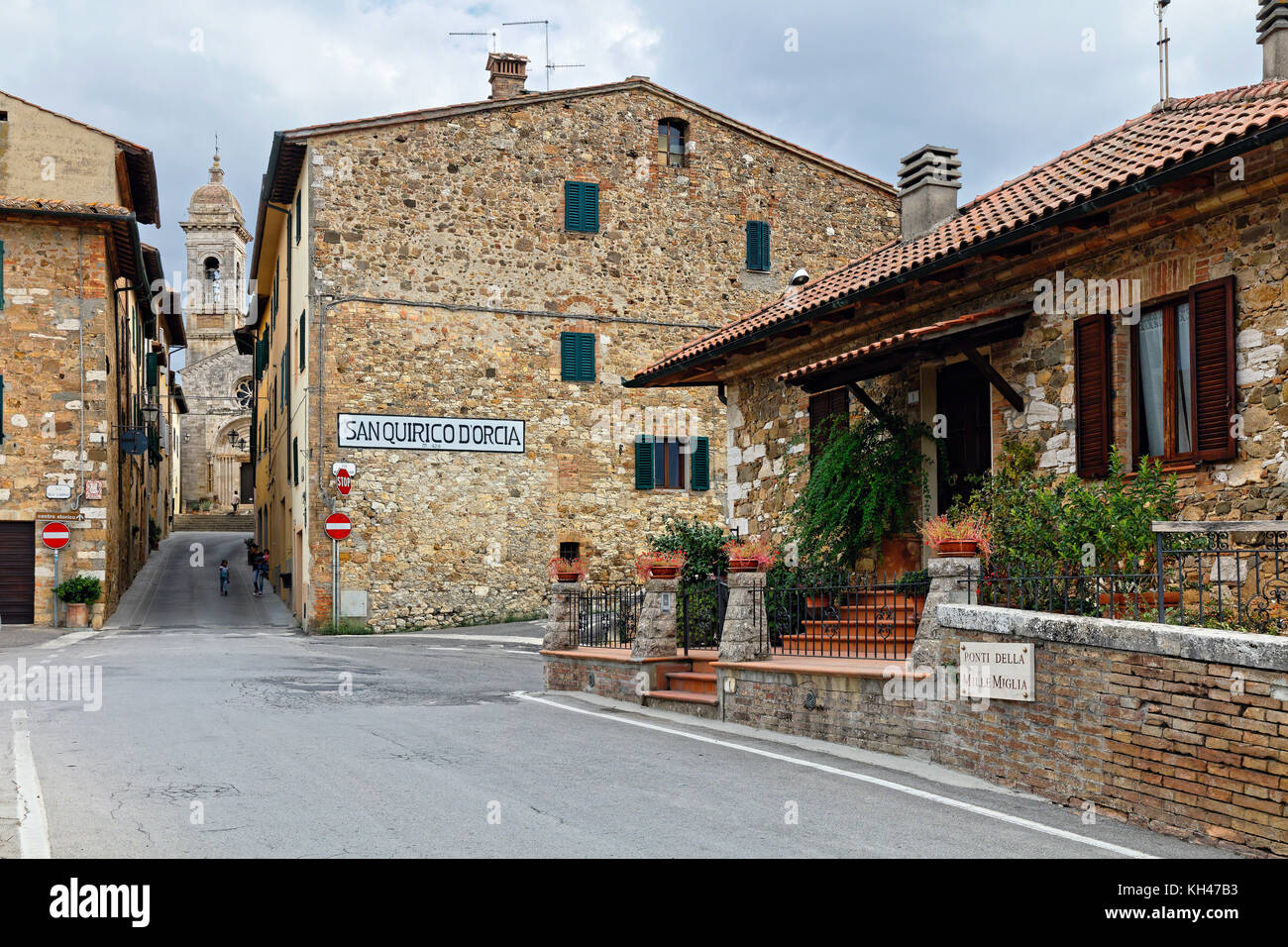 Narrow Street with the Collegiate church of San Quirico, Tuscany, Italy Stock Photo