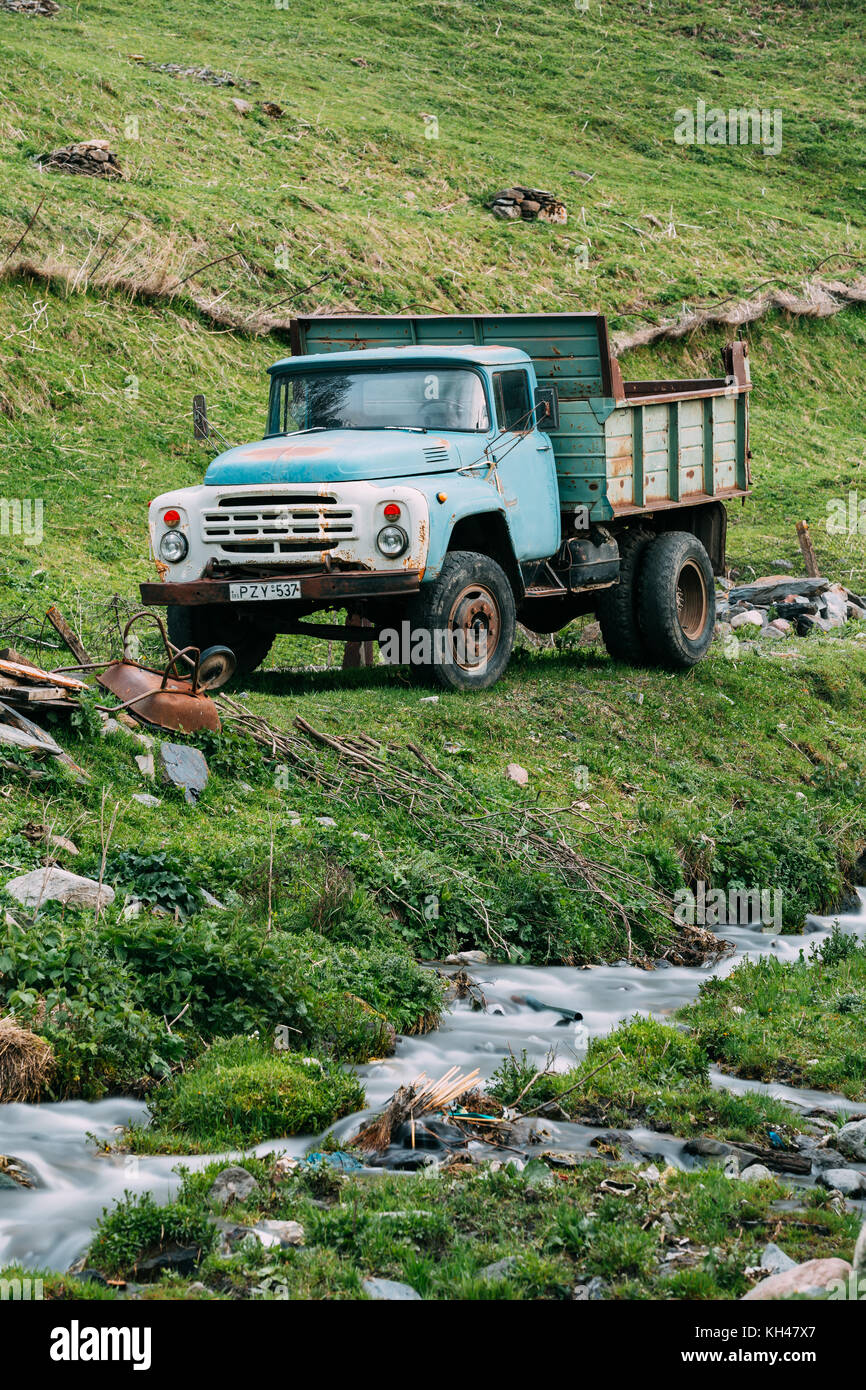 Georgia. ZIL-130 - Old Soviet Russian medium-duty truck parking near creek on summer grass in Kazbegi, Georgia Stock Photo