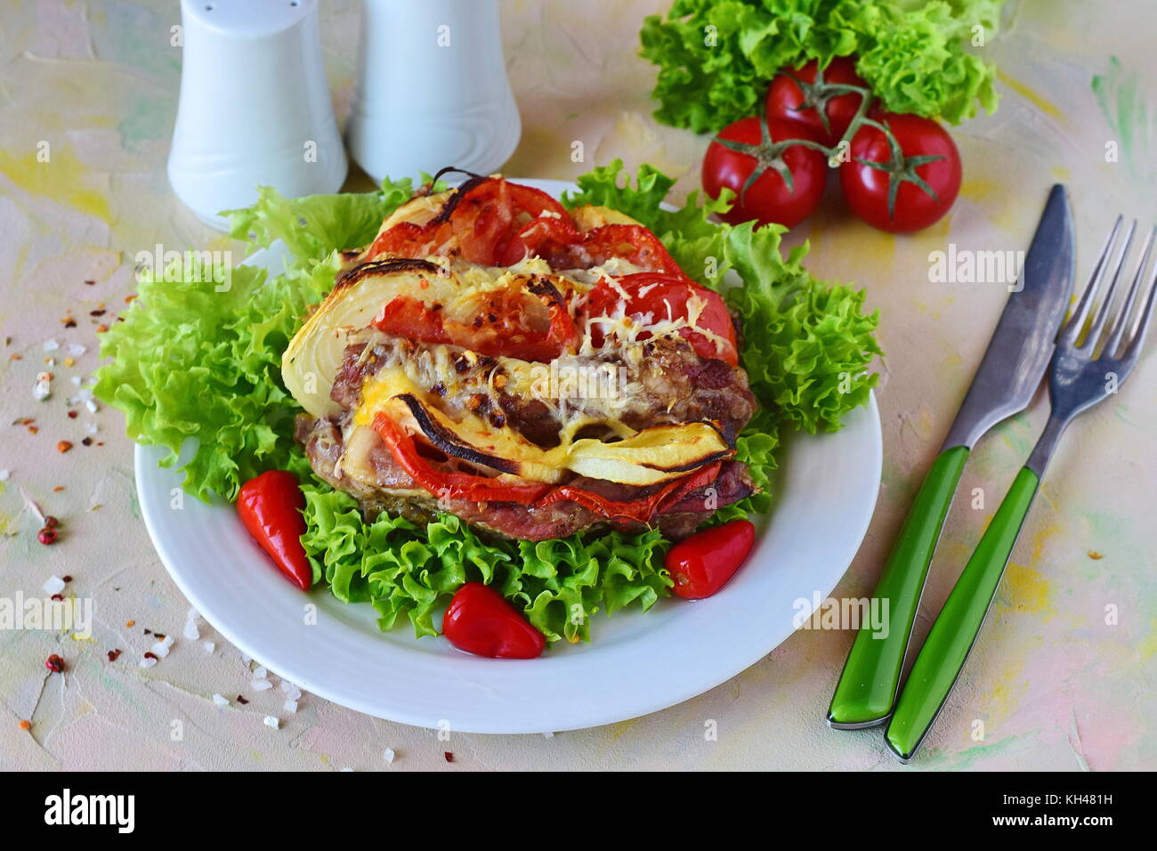 Stuffed pork roasted in oven with paprika, tomato and cheese in a white plate on abstract background Stock Photo