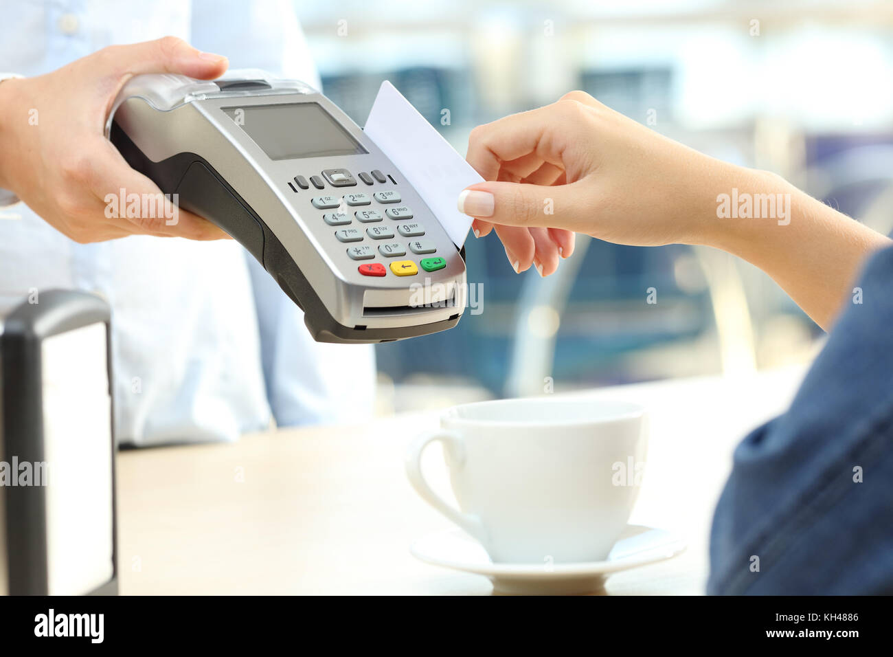 Close up of a waiter hand charging with credit card reader to a customer in a bar Stock Photo