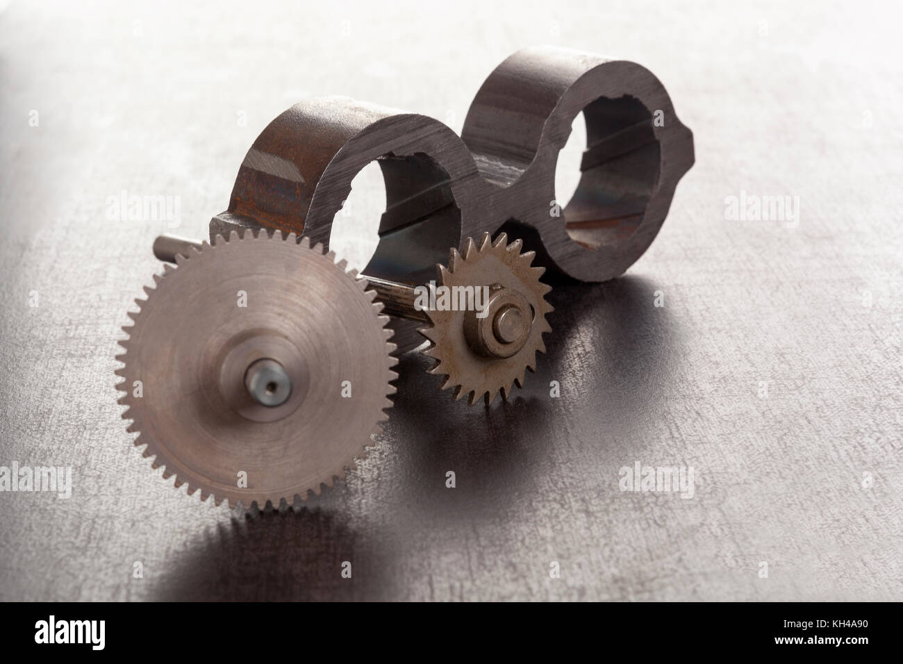 Cogwheels and mechanical component on concrete. Stock Photo