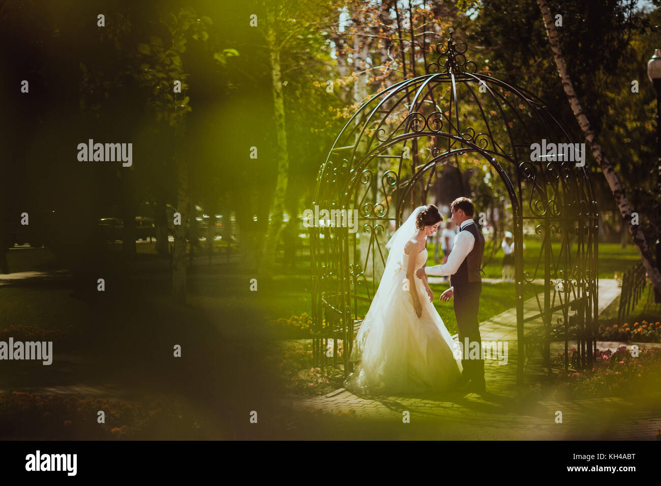 The bride and groom in the park arch Stock Photo - Alamy