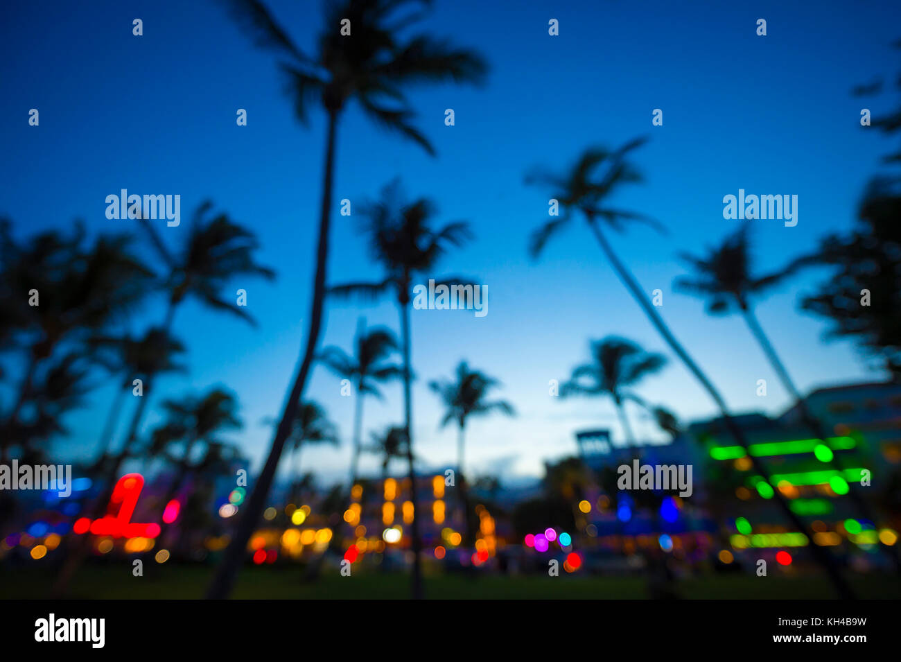 Defocused view at dusk of palm trees and neon lights of Ocean Drive in South Beach, Miami, Florida. Stock Photo