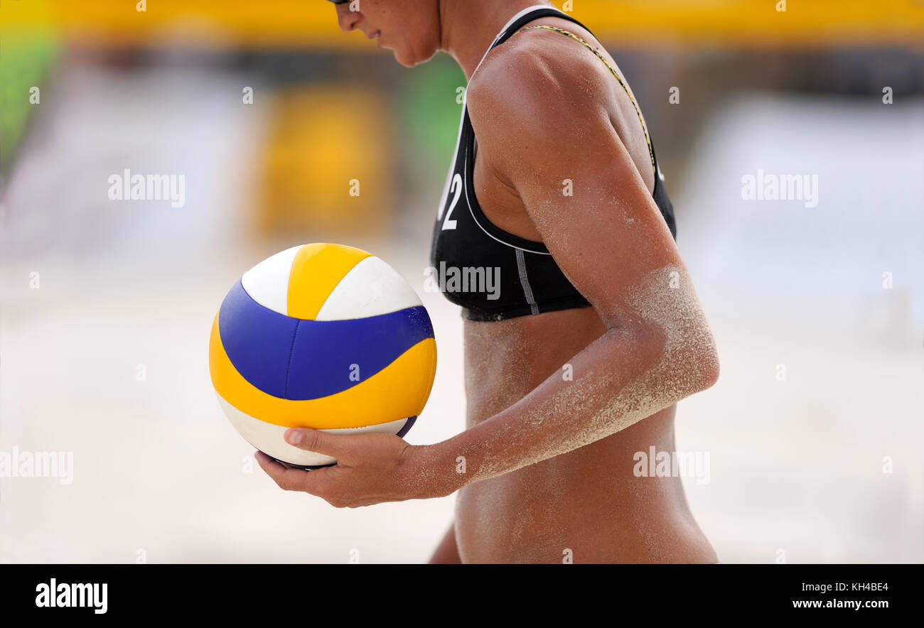 Volleyball beach is a female beach volleyball player getting ready to