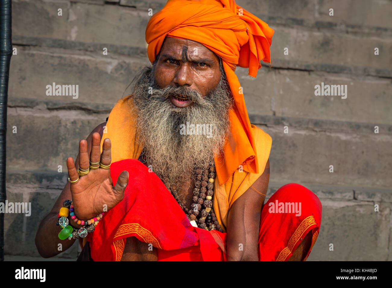 Holy sadhu man pose raising the blessing hand at the Ganga river bank in Varanasi, India. Stock Photo